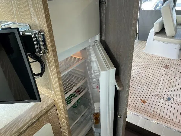 Azimut Magellano 53 Yacht Photos Pics Open fridge on Azimut Magellano 53 yacht, showcasing interior and deck area, 2020 model.