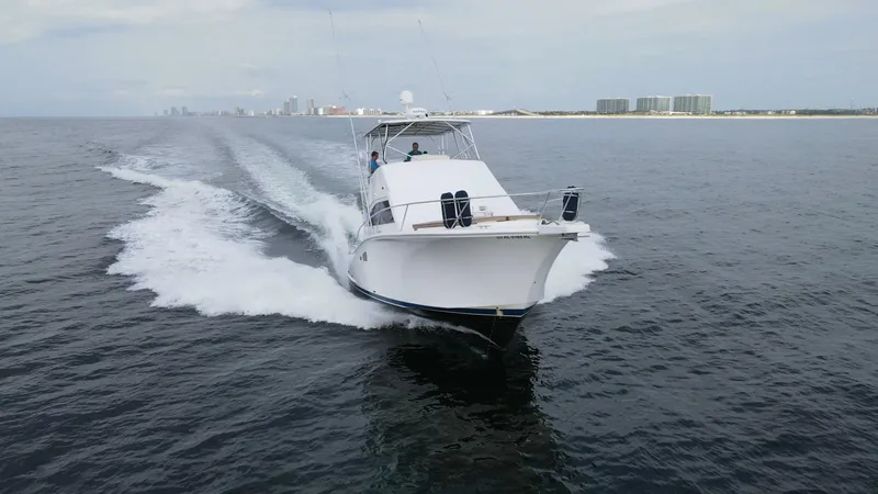 Pipe Dream Yacht Photos Pics 2008 Luhrs 35 Convertible yacht cruising on open water near a distant city skyline.