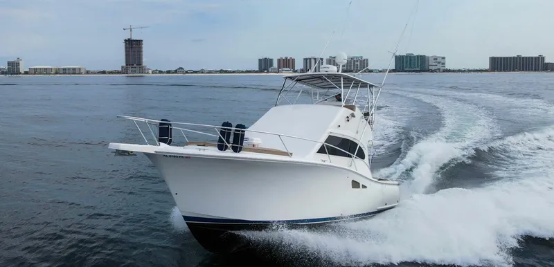 Pipe Dream Yacht Photos Pics 2008 Luhrs 35 Convertible yacht cruising on open water near city skyline.