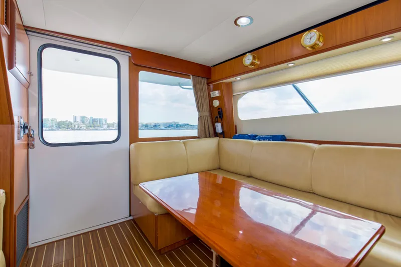 Pipe Dream Yacht Photos Pics Interior of 2008 Luhrs 35 Convertible yacht with beige seating and wooden table.