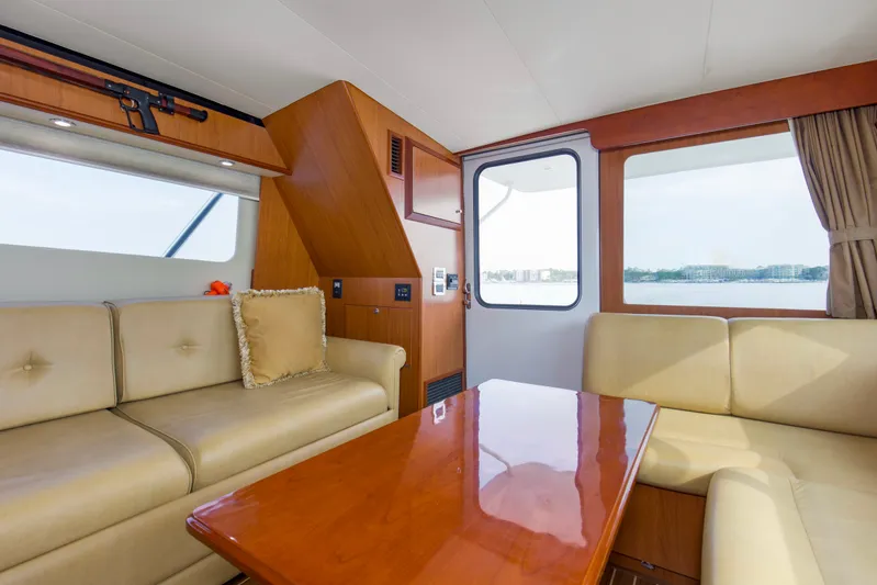 Pipe Dream Yacht Photos Pics Interior of 2008 Luhrs 35 Convertible yacht with beige seating and wooden table.