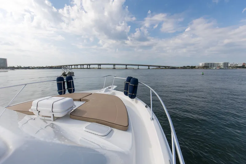 Pipe Dream Yacht Photos Pics 2008 Luhrs 35 Convertible yacht cruising under a cloudy sky near a bridge.