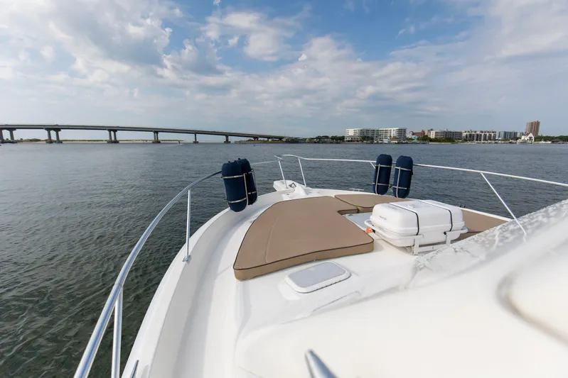 Pipe Dream Yacht Photos Pics 2008 Luhrs 35 Convertible boat on water near a bridge and cityscape.