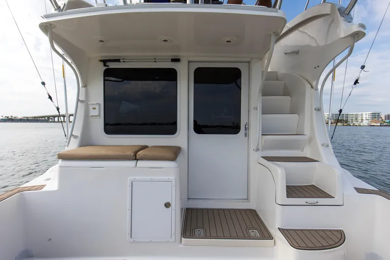 Pipe Dream Yacht Photos Pics 2008 Luhrs 35 Convertible boat with cushioned seating and stairs, docked by the water.