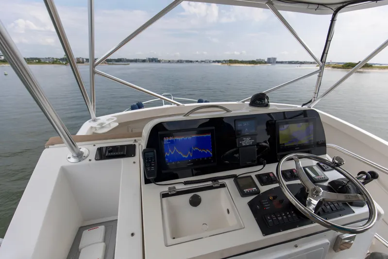 Pipe Dream Yacht Photos Pics 2008 Luhrs 35 Convertible boat helm with navigation screens and steering wheel, overlooking calm waters.