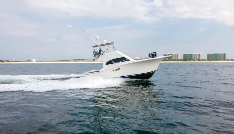 Pipe Dream Yacht Photos Pics 2008 Luhrs 35 Convertible yacht cruising on open water near a coastal cityscape.