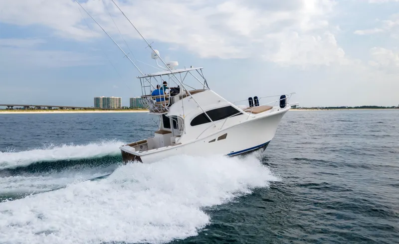 Pipe Dream Yacht Photos Pics 2008 Luhrs 35 Convertible yacht cruising on open water near a coastal cityscape.