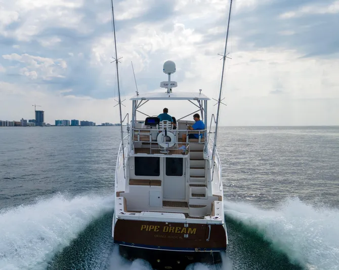Pipe Dream Yacht Photos Pics 2008 Luhrs 35 Convertible yacht cruising on open water, rear view.