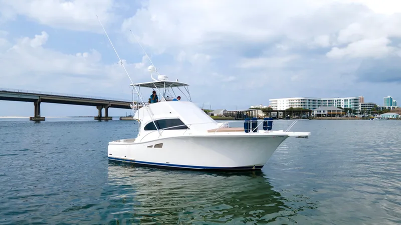 Pipe Dream Yacht Photos Pics 2008 Luhrs 35 Convertible yacht on water near a bridge and buildings.
