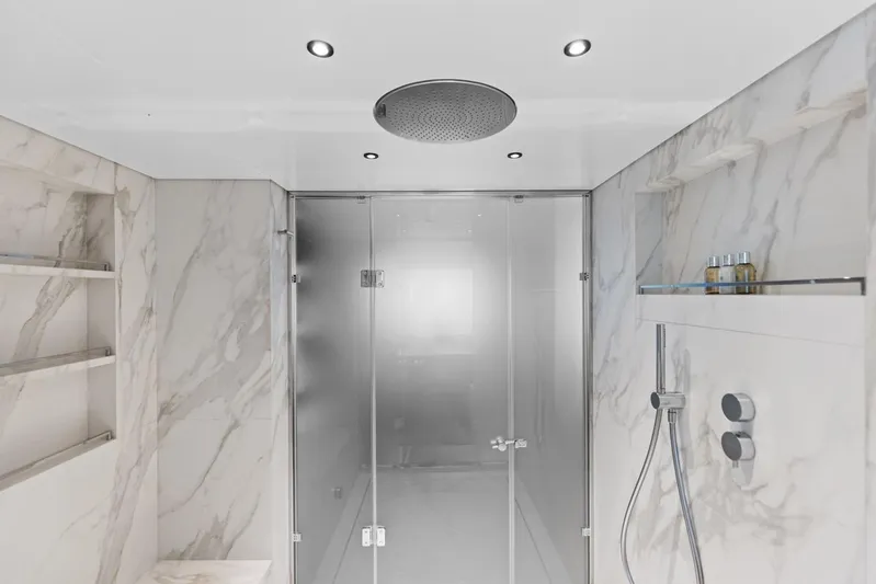 Contigo Yacht Photos Pics Luxurious bathroom in 2024 Benetti 40M Oasis yacht with marble walls and modern shower.