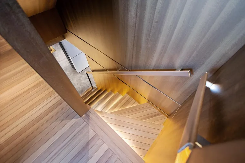 Contigo Yacht Photos Pics Luxurious wooden staircase inside 2024 Benetti 40M Oasis yacht, showcasing elegant design.