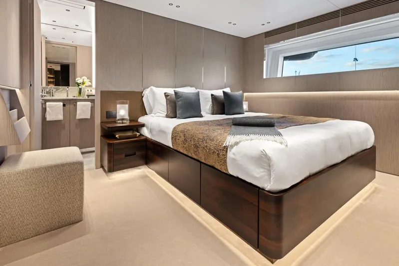 Contigo Yacht Photos Pics Luxurious bedroom in 2024 Benetti 40M Oasis yacht with modern decor and large window.