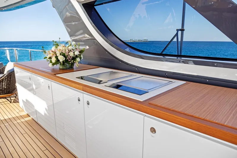 Contigo Yacht Photos Pics Luxurious 2024 Benetti 40M Oasis yacht kitchen with ocean view and elegant floral arrangement.