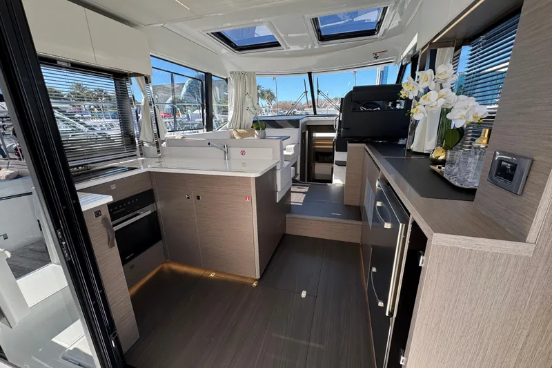  Yacht Photos Pics Modern interior of 2026 Jeanneau NC 1295 Coupe yacht with sleek kitchen design.