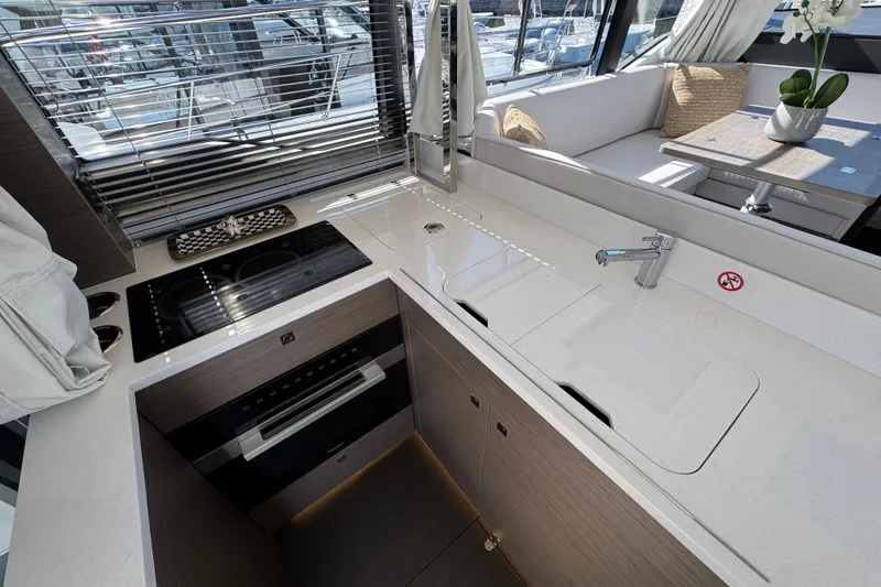  Yacht Photos Pics Modern kitchen interior of 2026 Jeanneau NC 1295 Coupe yacht with sleek design.