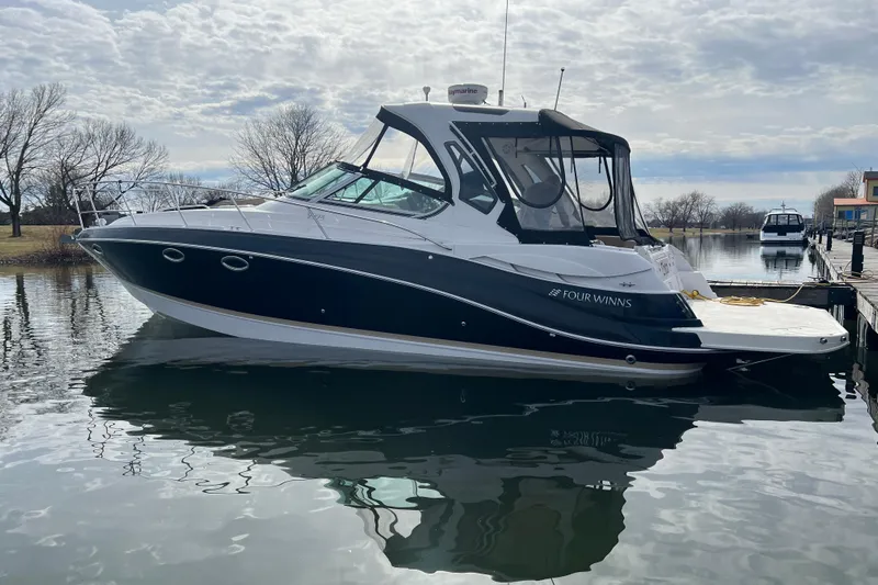  Yacht Photos Pics 2015 Four Winns 375 Vista boat docked on a calm lake under cloudy skies.