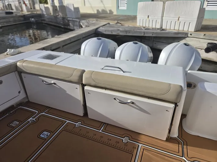 No Name Yacht Photos Pics 2019 Pursuit OS 385 Offshore boat deck with storage compartments and triple outboard engines.
