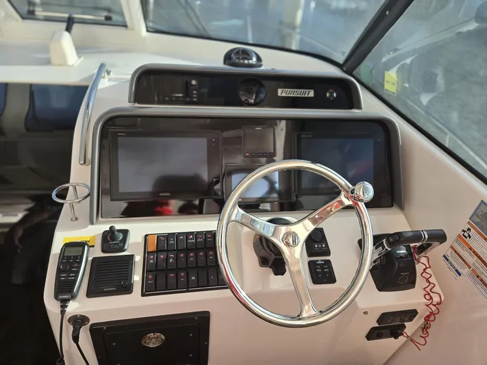 No Name Yacht Photos Pics 2019 Pursuit OS 385 Offshore boat helm with steering wheel and navigation controls.
