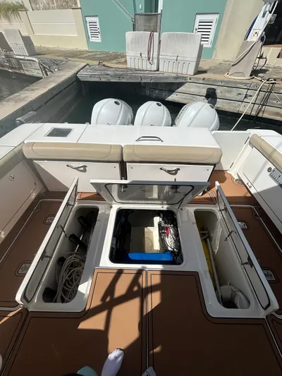 No Name Yacht Photos Pics 2019 Pursuit OS 385 Offshore boat with open storage compartments and triple outboard engines.