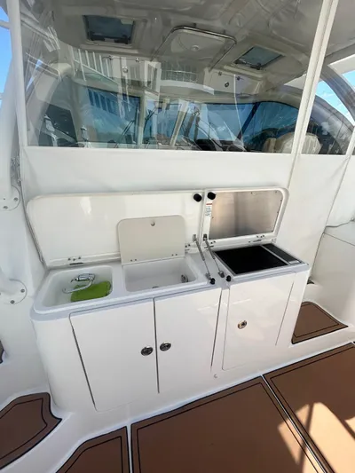 No Name Yacht Photos Pics 2019 Pursuit OS 385 Offshore boat interior with kitchenette and sink.