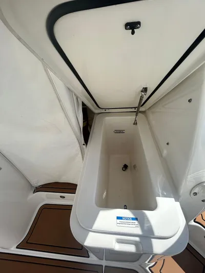 No Name Yacht Photos Pics 2019 Pursuit OS 385 Offshore boat storage compartment, open lid, white interior.