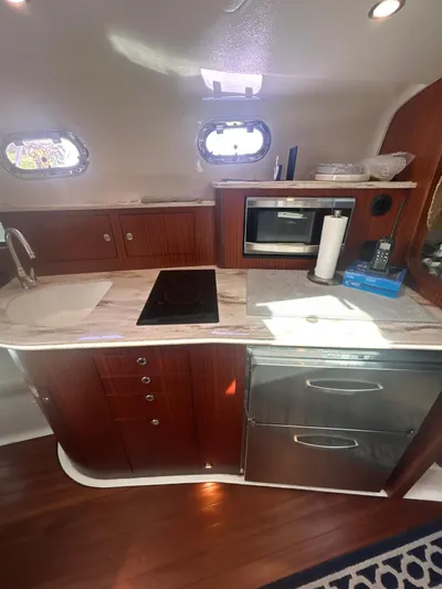 No Name Yacht Photos Pics 2019 Pursuit OS 385 Offshore yacht kitchen with modern appliances and wooden cabinetry.