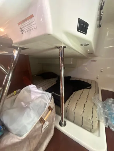 No Name Yacht Photos Pics 2019 Pursuit OS 385 Offshore cabin interior with bed and storage area.