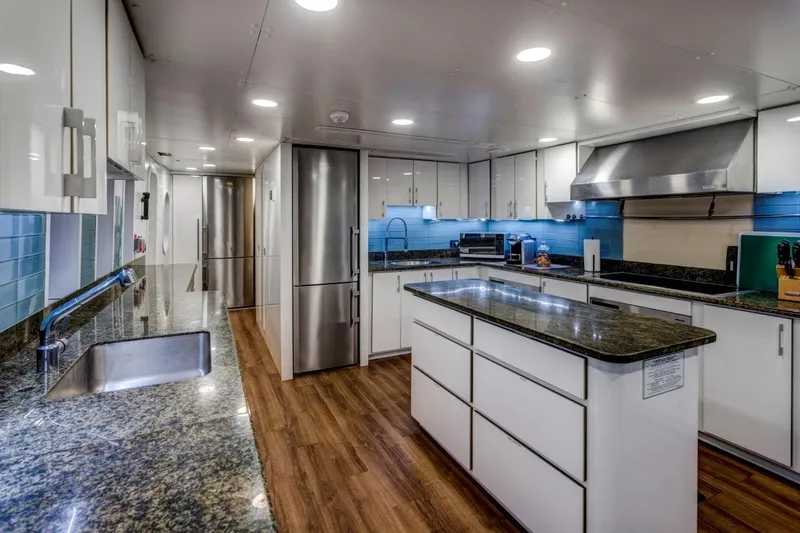 Ionian Princess Yacht Photos Pics Modern kitchen with granite countertops, stainless steel appliances, and wood flooring on a Christensen 2005 model.