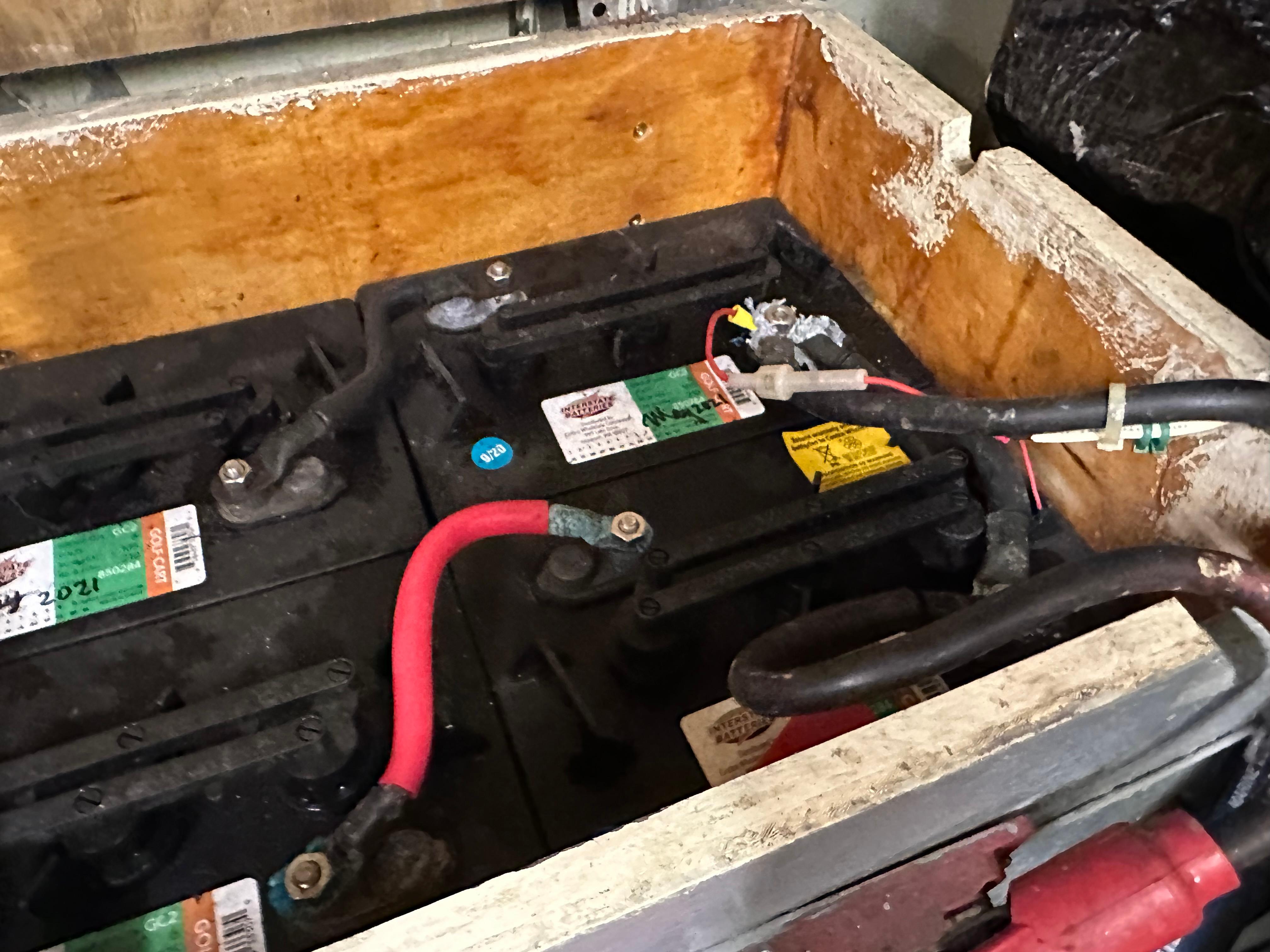 Batteries in a wooden compartment of a 1978 Rival 41C boat.