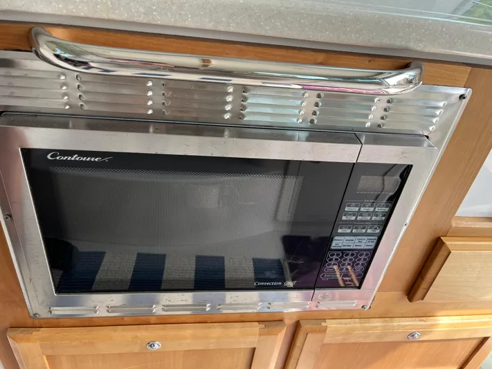  Yacht Photos Pics Microwave in 2016 Back Cove 34 Express yacht kitchen, featuring wooden cabinetry.
