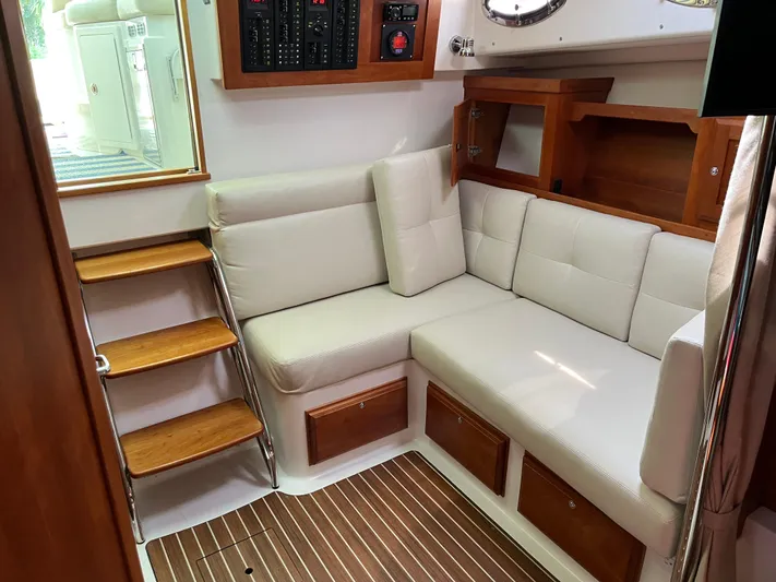  Yacht Photos Pics 2016 Back Cove 34 Express interior with white seating, wooden steps, and storage cabinets.