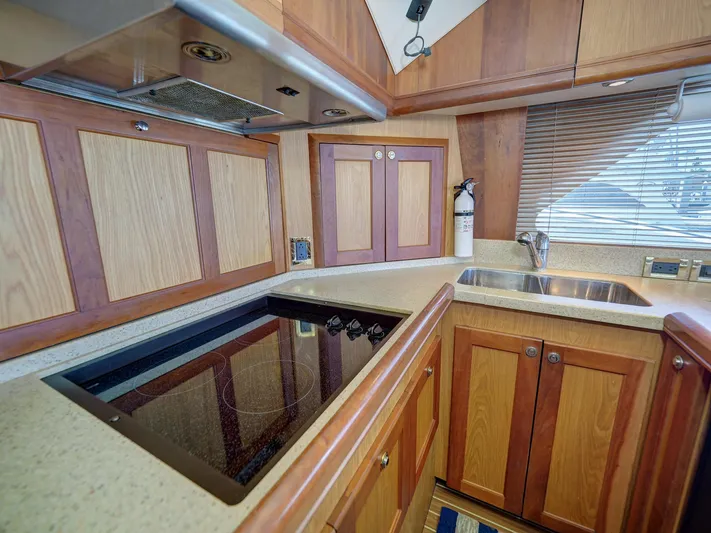 Tight Seal Yacht Photos Pics 2005 Luhrs 41 Convertible yacht kitchen with stove, sink, and wooden cabinets.