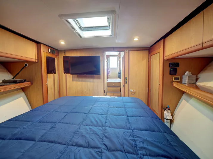 Tight Seal Yacht Photos Pics 2005 Luhrs 41 Convertible cabin with skylight, TV, and blue bedding.
