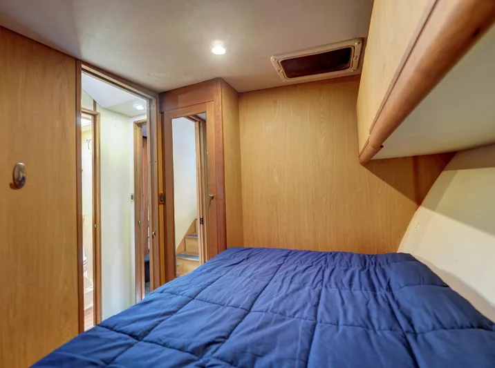 Tight Seal Yacht Photos Pics 2005 Luhrs 41 Convertible cabin with blue bedding and wooden interior.