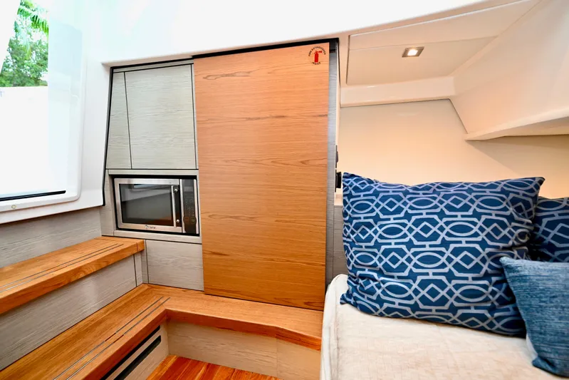S.y. Royale Yacht Photos Pics 2023 Tiara Sport 38 LS interior with wood accents and blue patterned pillows.