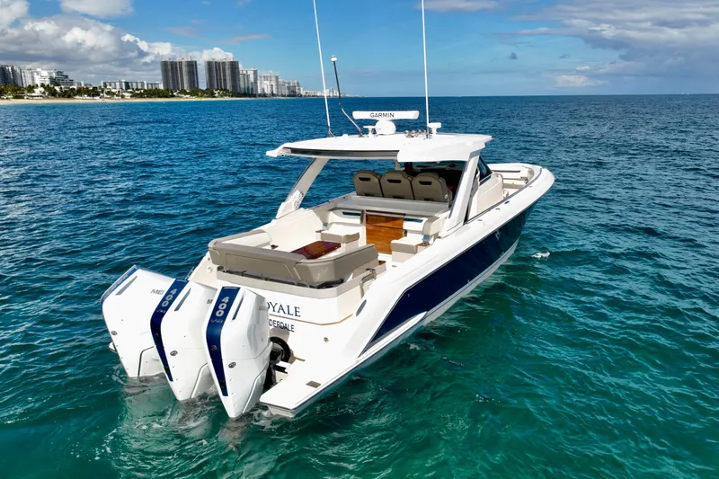 S.y. Royale Yacht Photos Pics 2023 Tiara Sport 38 LS boat on clear blue ocean near city skyline.