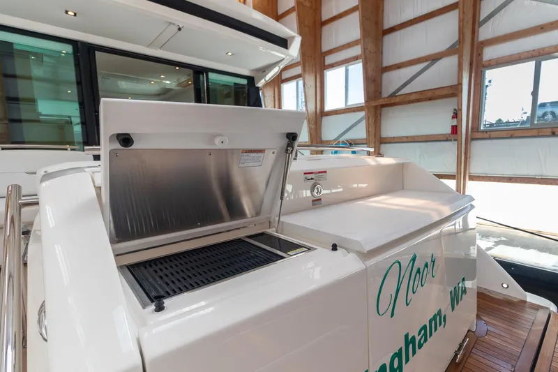 Noor Yacht Photos Pics 2023 Tiara Yachts C44 Coupe with outdoor grill in a wooden boathouse.