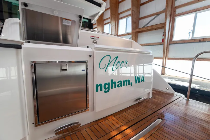 Noor Yacht Photos Pics 2023 Tiara Yachts C44 Coupe docked, featuring teak deck and stainless steel details.