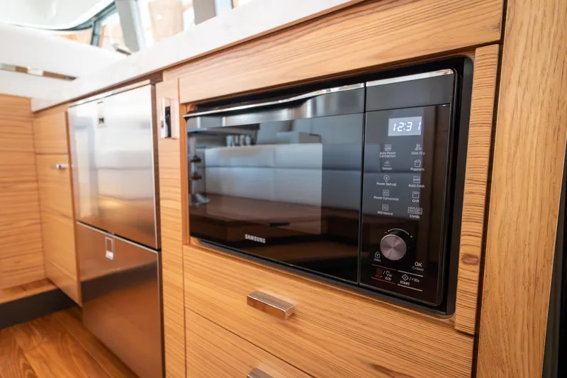 Noor Yacht Photos Pics 2023 Tiara Yachts C44 Coupe kitchen with modern appliances and wood cabinetry.