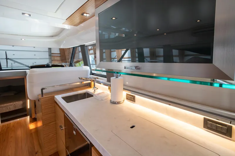 Noor Yacht Photos Pics Modern kitchen interior of 2023 Tiara Yachts C44 Coupe with sleek countertops and ample lighting.