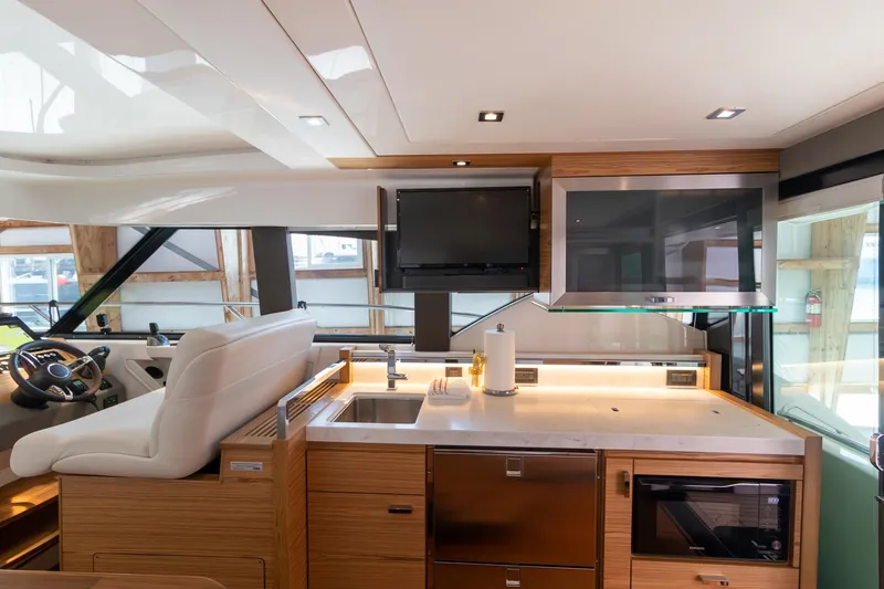 Noor Yacht Photos Pics Luxurious interior of 2023 Tiara Yachts C44 Coupe with modern kitchen and helm station.