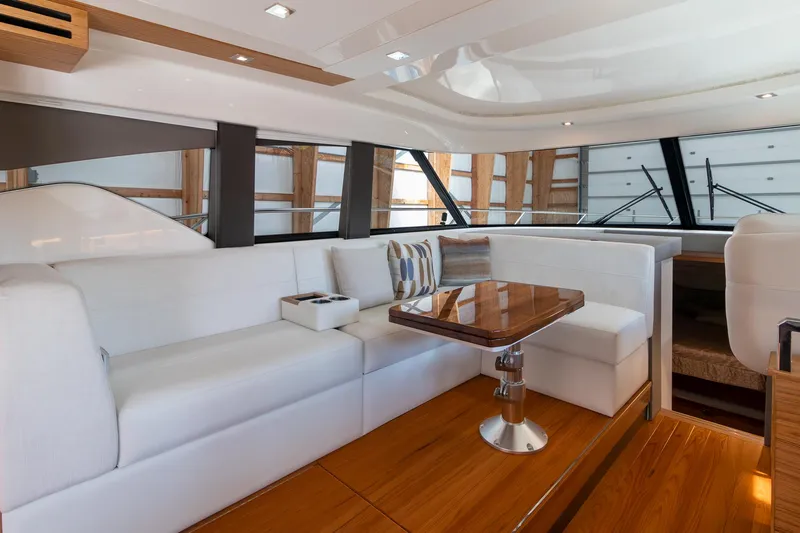 Noor Yacht Photos Pics Luxurious interior of 2023 Tiara Yachts C44 Coupe with elegant seating and wooden table.