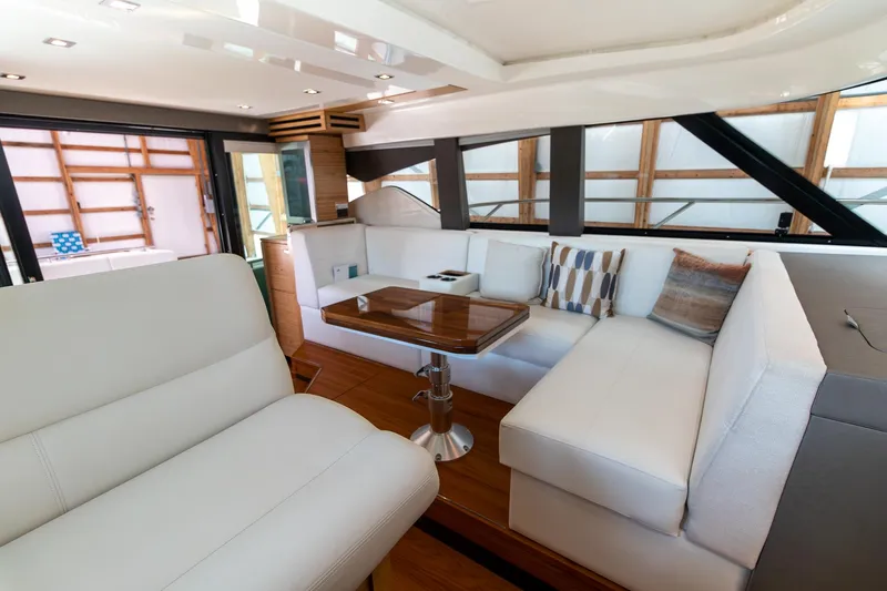 Noor Yacht Photos Pics 2023 Tiara Yachts C44 Coupe interior with elegant white seating and wooden table.