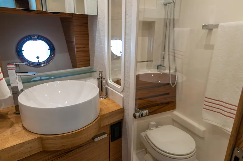 Noor Yacht Photos Pics Luxurious bathroom in 2023 Tiara Yachts C44 Coupe, featuring modern sink and shower.