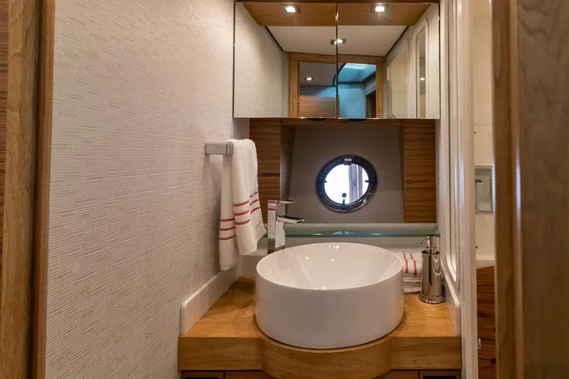 Noor Yacht Photos Pics Luxurious bathroom in 2023 Tiara Yachts C44 Coupe with modern fixtures and porthole window.