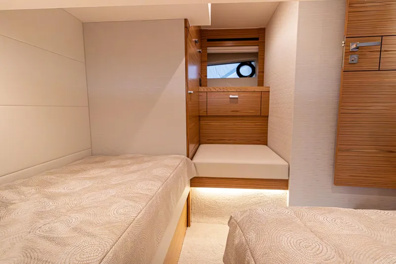 Noor Yacht Photos Pics 2023 Tiara Yachts C44 Coupe cabin interior with twin beds and wooden cabinetry.