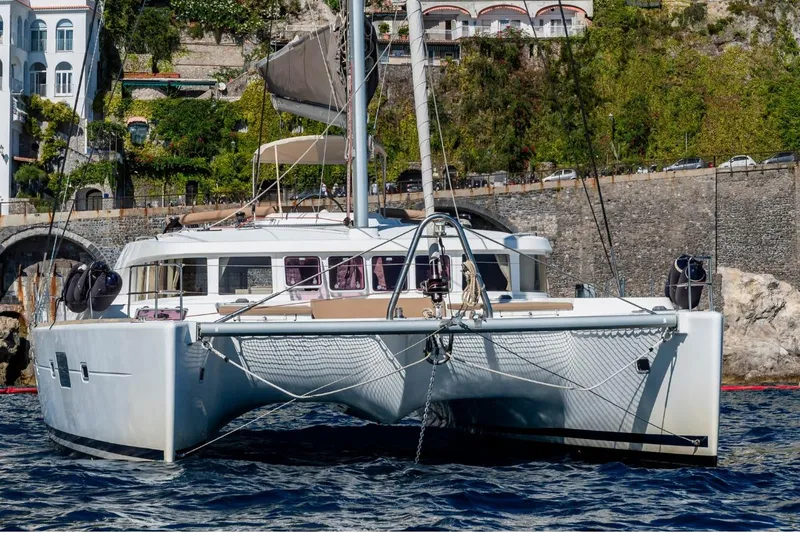  Yacht Photos Pics 2011 Lagoon LAGOON 500 catamaran docked near scenic coastal architecture.