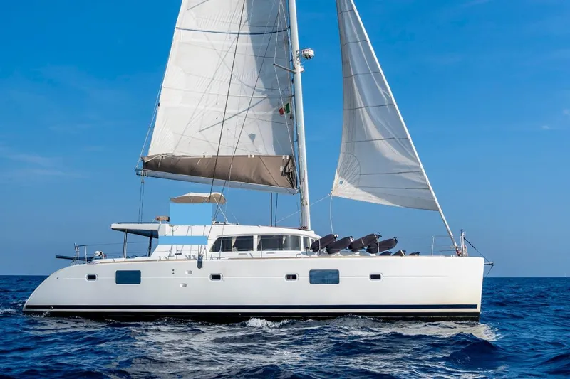  Yacht Photos Pics Sailing catamaran Lagoon 500, 2011 model, cruising on open sea under clear blue sky.