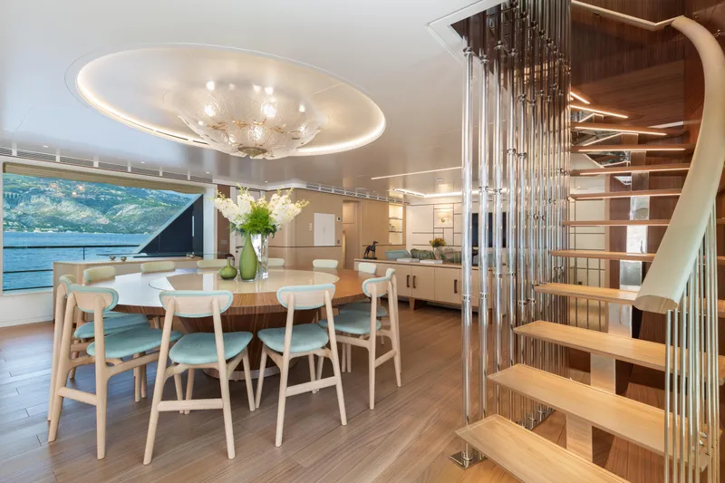 Miss Candy Yacht Photos Pics Luxurious Versilcraft HS 2022 yacht interior with elegant dining area and modern spiral staircase.