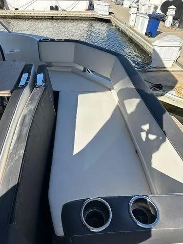 This Could Be Yours Yacht Photos Pics 2023 Bavaria R40 Coupe boat interior with cushioned seating and cup holders at a marina.